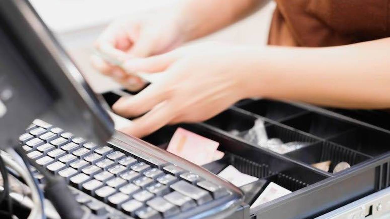 Cashier counting money in register