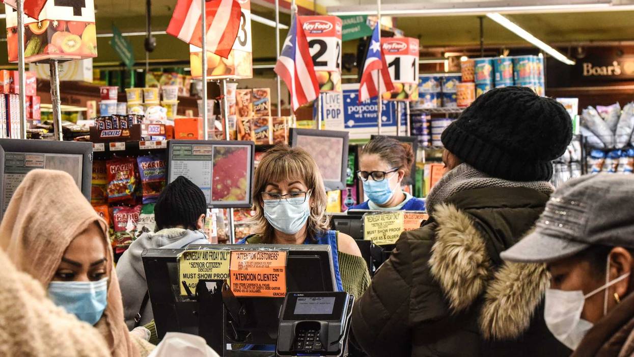 Cashiers and customers wear masks in a grocery store in Bushwick, Brooklyn