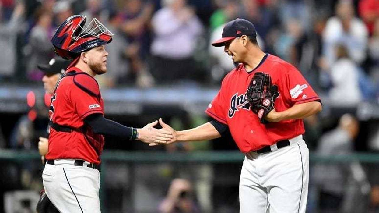 Catcher Roberto Perez #55 celebrates with closing pitcher Carlos Carrasco #59 of the Cleveland Indians