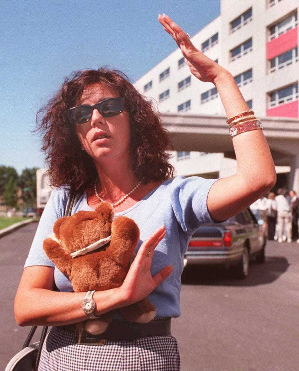 Catherine Cayrol from France, holding a stuffed bear, speaks to reporters 21 July outside the Ramada Inn at Kennedy Airport in New York where families of the victims of TWA flight 800 are staying. Catherine Cayrol