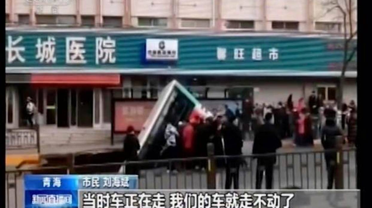 CCTV video, a bus plunges into a sinkhole in the center of a downtown street, Monday, Jan. 13, 2020, in Xining, Qinghai province, China.
