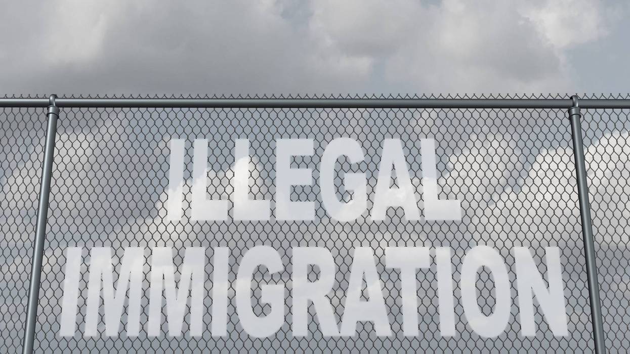 chain fence with a hole shaped as text that represents people illegally crossing a national border violating the migration law of the country