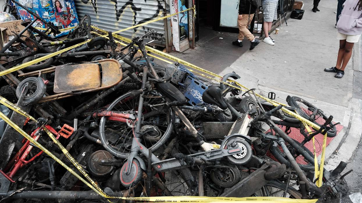 Charred remains of e-bikes and scooters sit outside of a building in Chinatown after four people were killed by a fire in an e-bike repair shop overnight on June 20, 2023 in New York City.