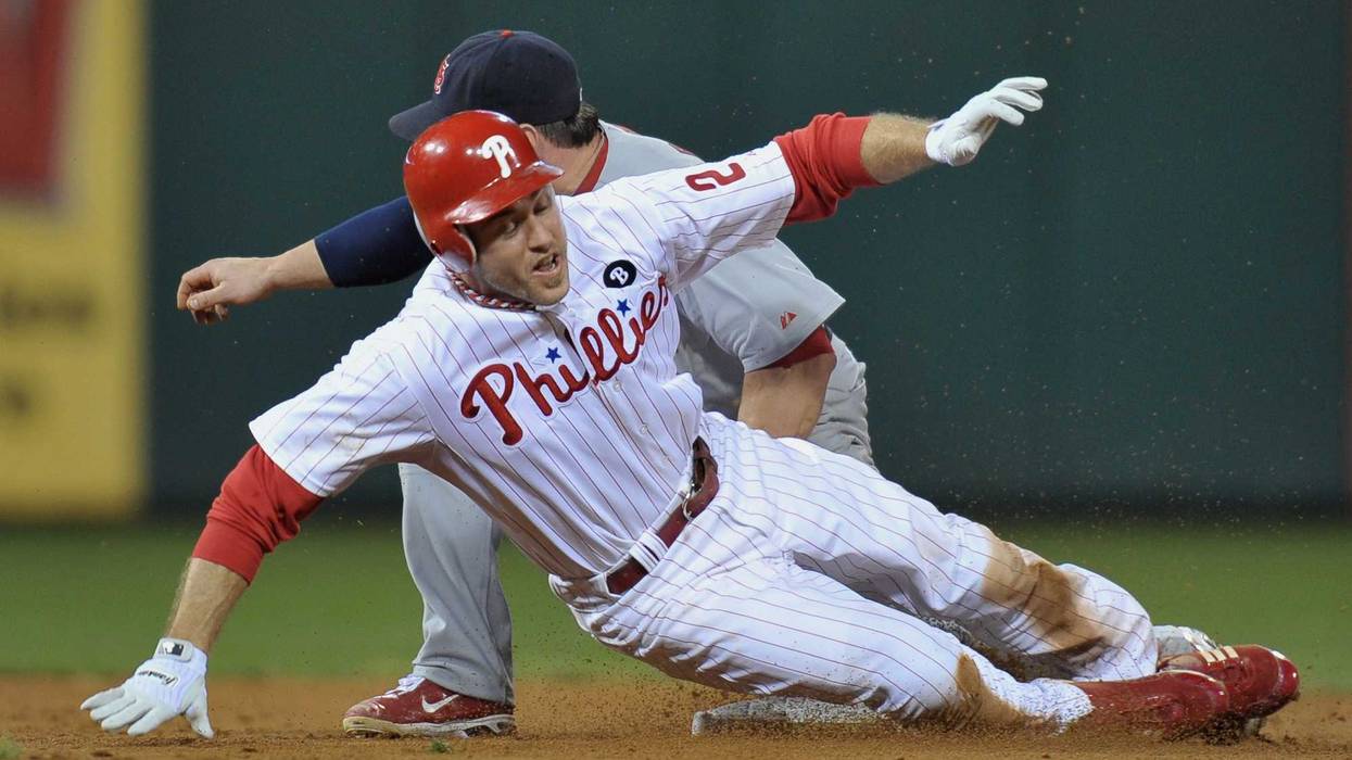 Chase Utley, #26 of the Philadelphia Phillies, is caught attempting to steal second base in the bottom of the sixth inning against Nick Punto, #8 of the St. Louis Cardinals, during Game Five of the National League Divisional Series at Citizens Bank Park on Oct. 7, 2011, in Philadelphia, Pennsylvania.