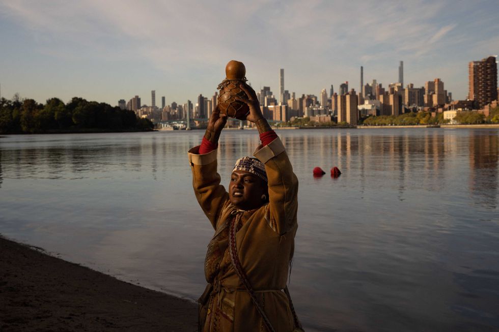 Chenae Bullock, of The Shinnecock Indian Nation, holds a traditional container of water during an Indigenous Peoples