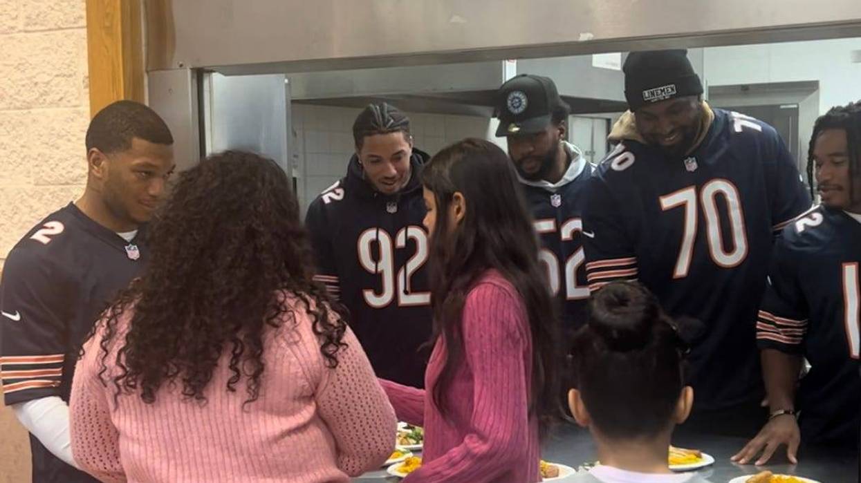 Chicago Bears players, including wide receiver D.J. Moore (left), volunteered Tuesday to help serve a Thanksgiving feast to migrants who recently arrived in the city.