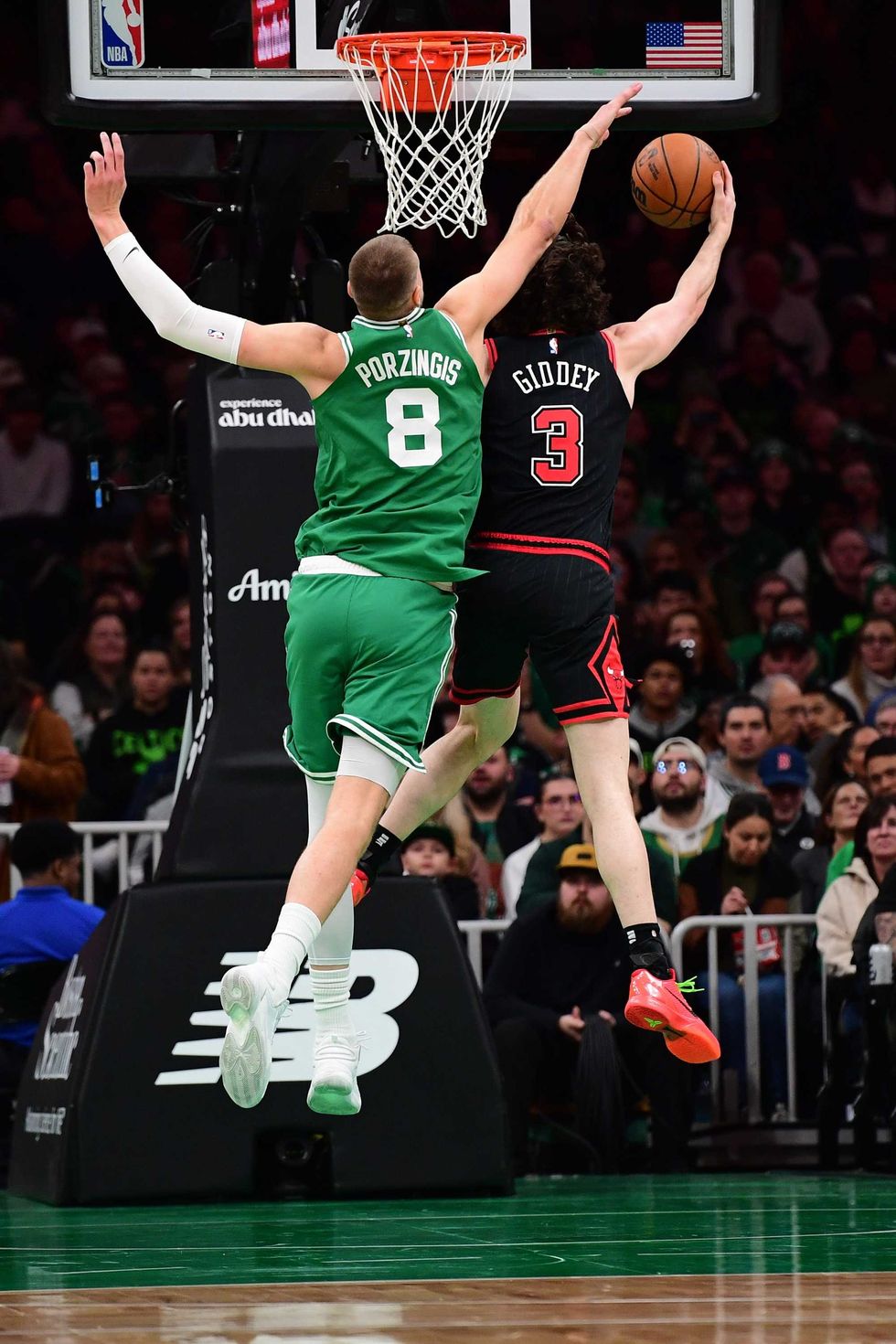Chicago Bulls guard Josh Giddey (3) lays the ball in the basket past Boston Celtics center Kristaps Porzingis (8) during the first half at TD Garden.