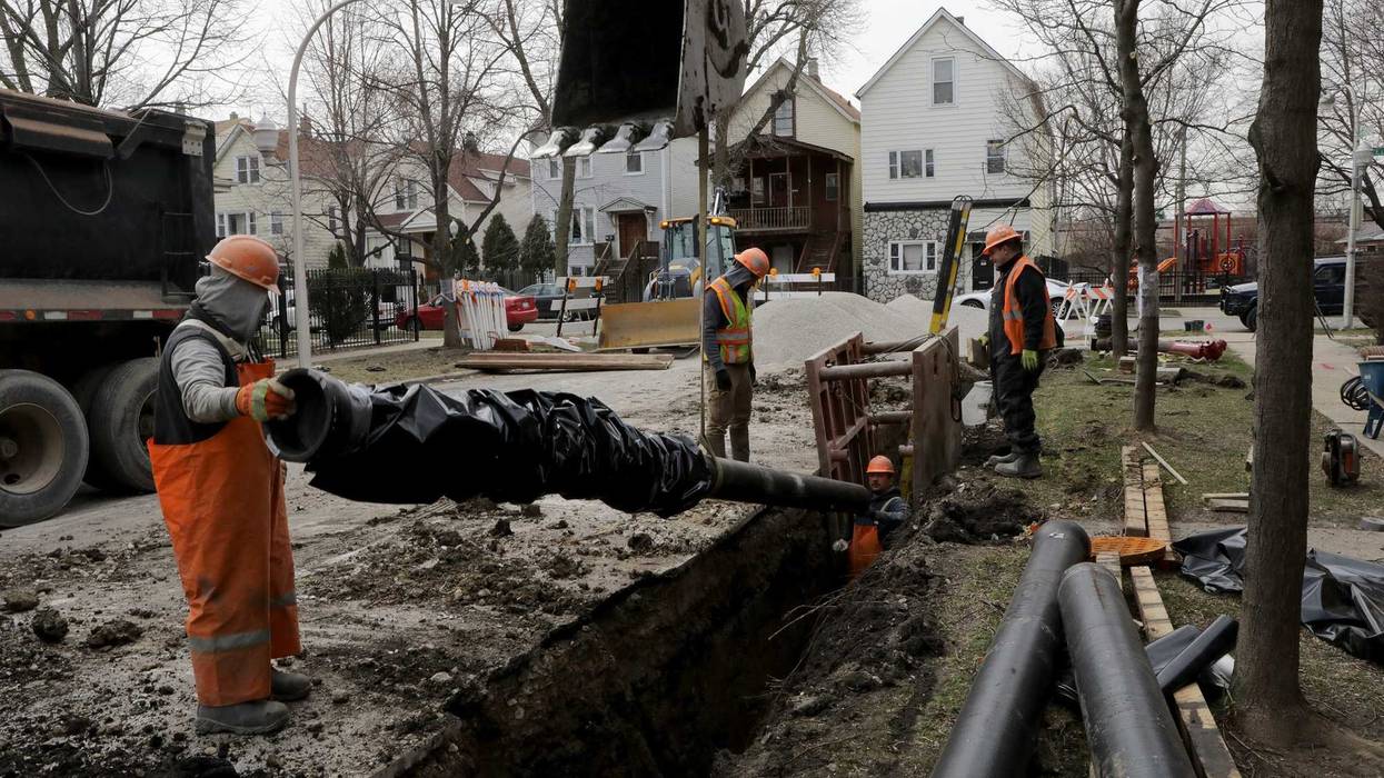 Chicago Department of Water Management crews install a 20-foot length, 8-inch water main pipe in the 3100 block of north Richmond Street on Monday, April 2, 2018, in Chicago.