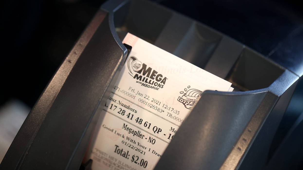 CHICAGO, ILLINOIS - JANUARY 22: A customer purchases a Mega Millions lottery ticket at a 7-Eleven store in the Loop on January 22, 2021 in Chicago, Illinois. The jackpot in the drawing has climbed to $970 million, the third highest in the game's history.