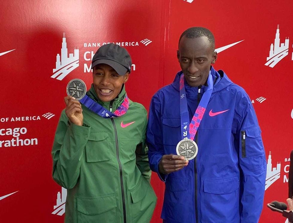 Chicago Marathon winners Sifan Hassan on the left, and Kelvin Kiptum post with their medals.