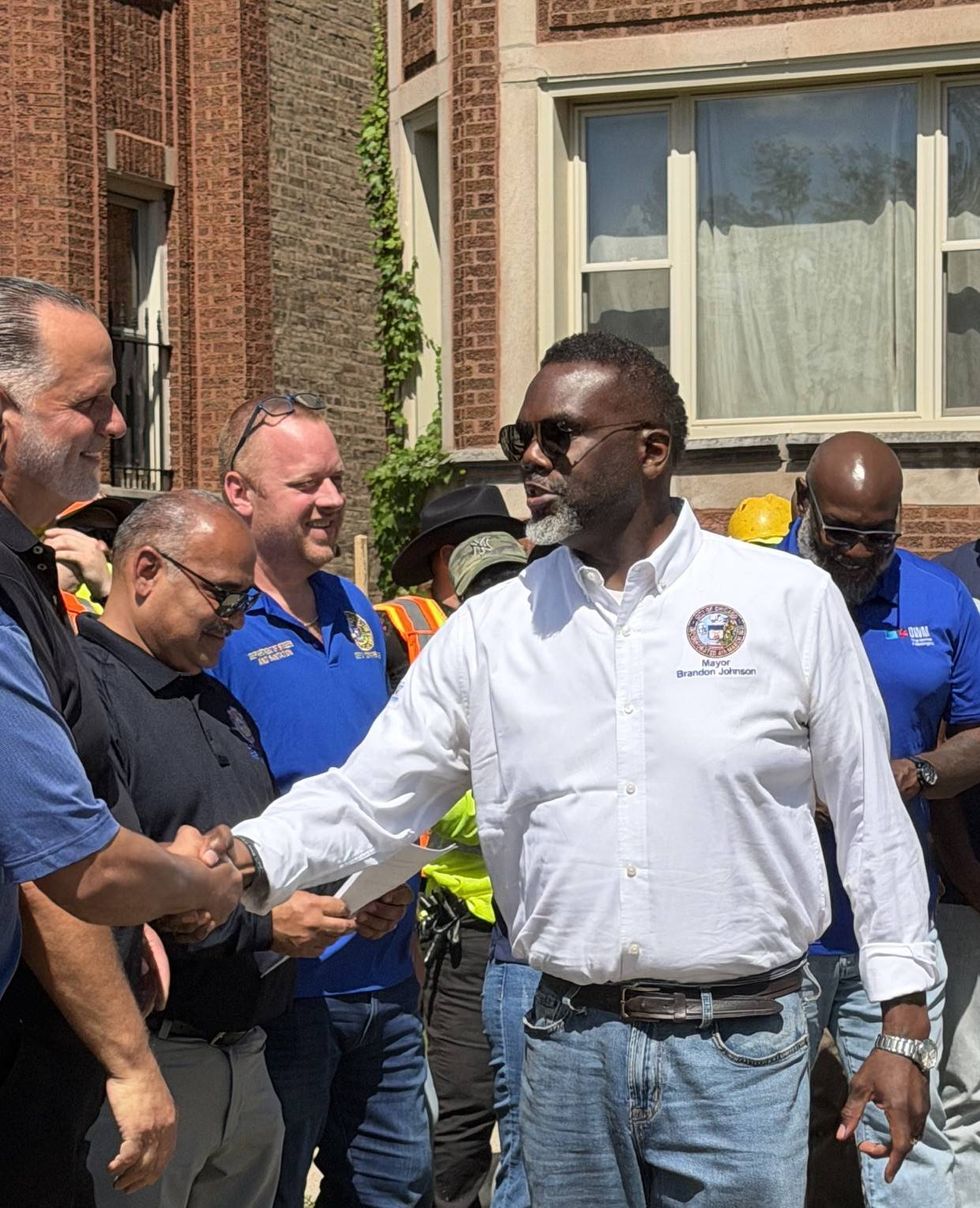 Chicago Mayor Brandon Johnson thanks city workers and department heads before updating reporters on storm cleanup in front of a home near 81st and Michigan in Chatham on the city's South side.