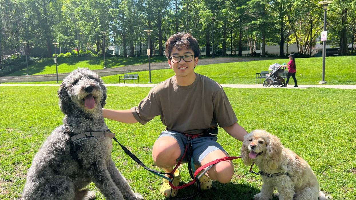 Chicago resident Gabriel Sindac poses for a photo in Lakeshore East with his dogs Monty and Poe. He was one of many Chicagoans braving the extreme heat Monday morning.