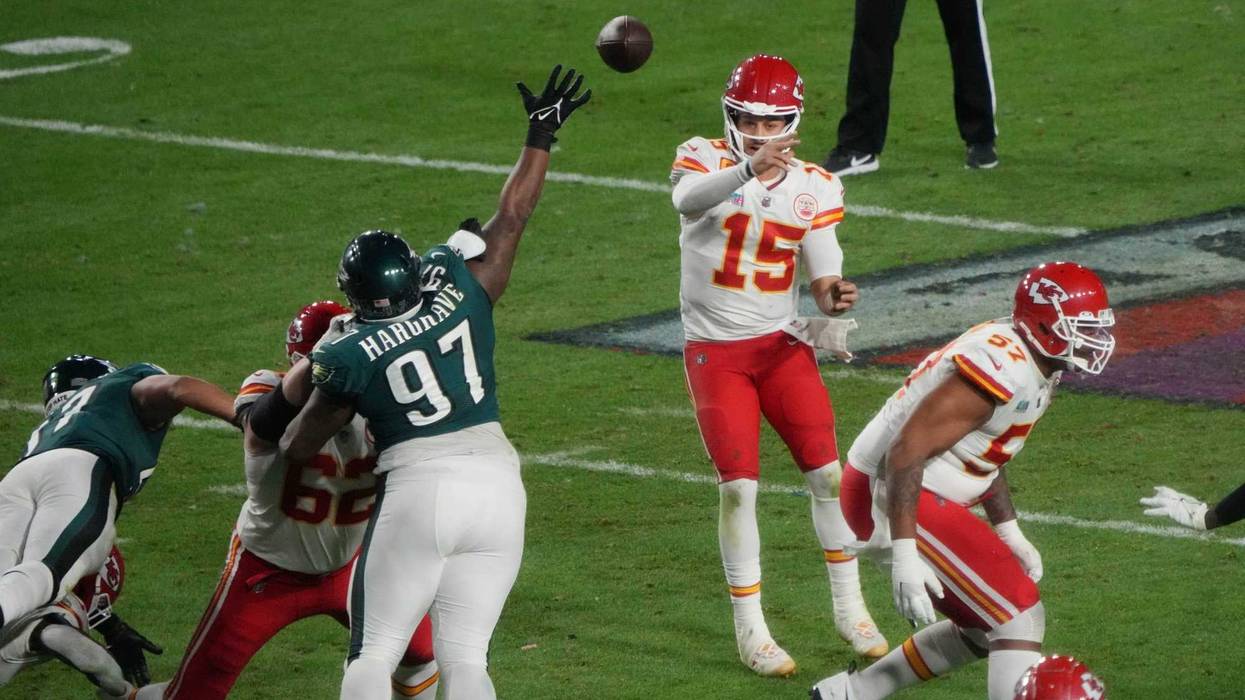 Chiefs quarterback Patrick Mahomes looks for an opening in the defense as Eagles lineman Javon Hargrave gets in his face during Super Bowl 57.