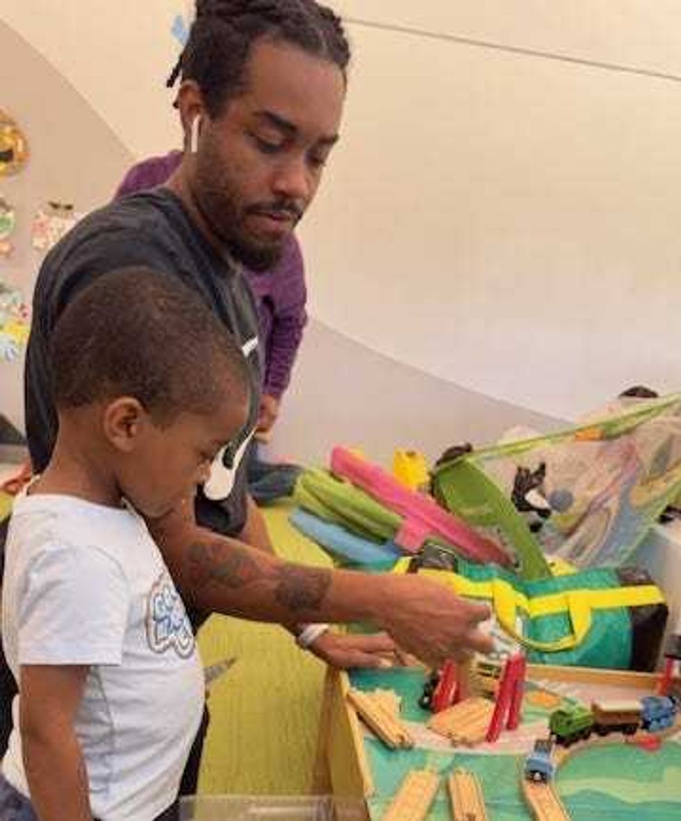 child and parent playing with trains