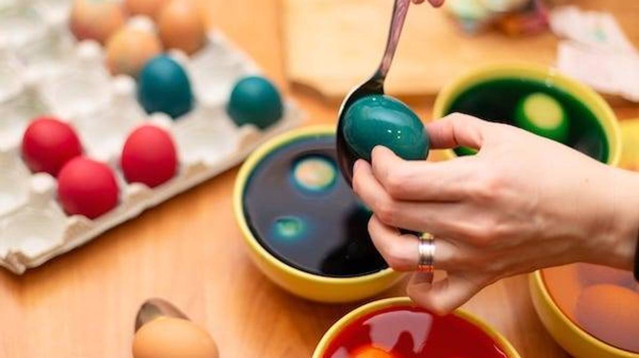 Child dyeing Easter eggs in a bowl