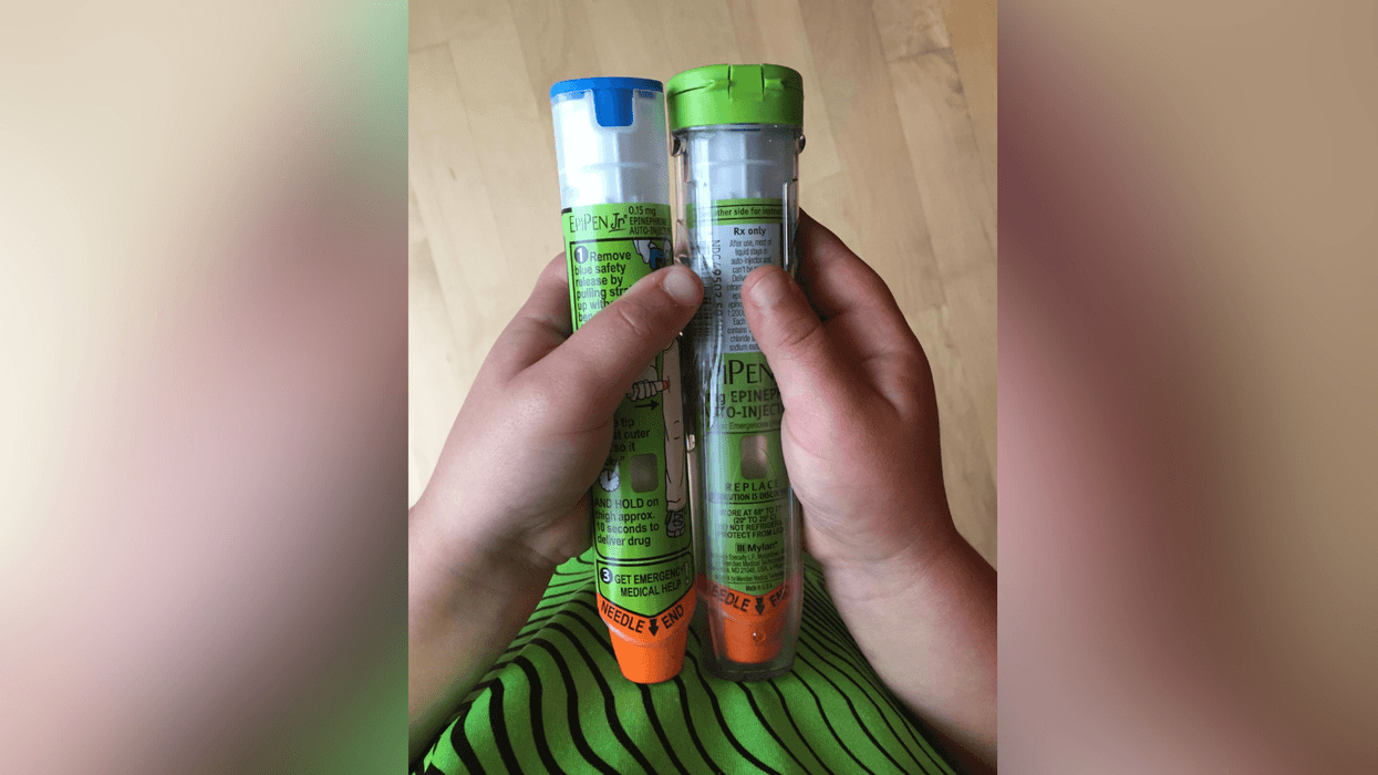 Child holding two EpiPens.