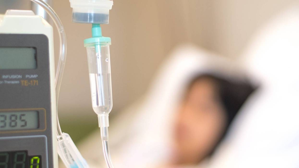 Child patient with IV line in hand sleep on hospital bed.