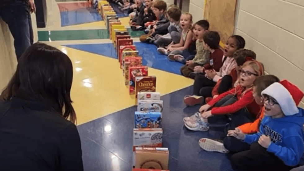 Children cheer during a cereal domino rally
