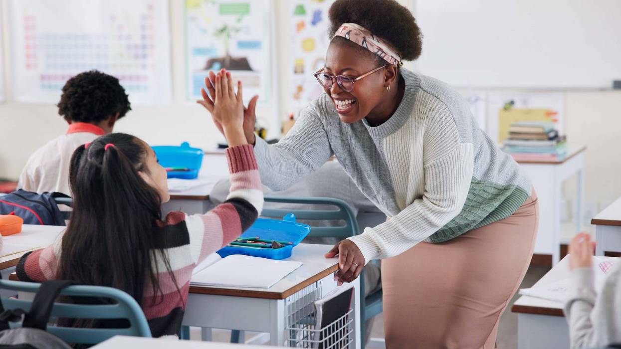 Children, education or high five with student and teacher in classroom together for motivation or success. Learning, support and study with congratulations of educator for achievement of girl pupil