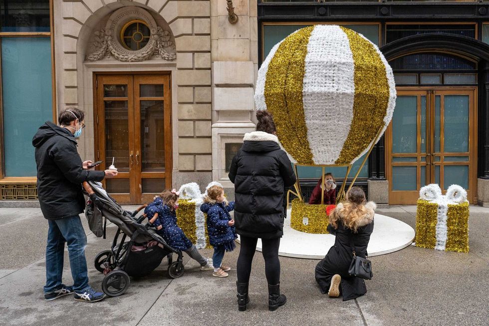 Children pose for photos at a sculpture of a hot air ballon on December 25, 2020 in New York City. People are celebrating Christmas during the pandemic as the city reports an increase of nearly 2,900 new cases and a 7 day positivity rate of 6.29%.