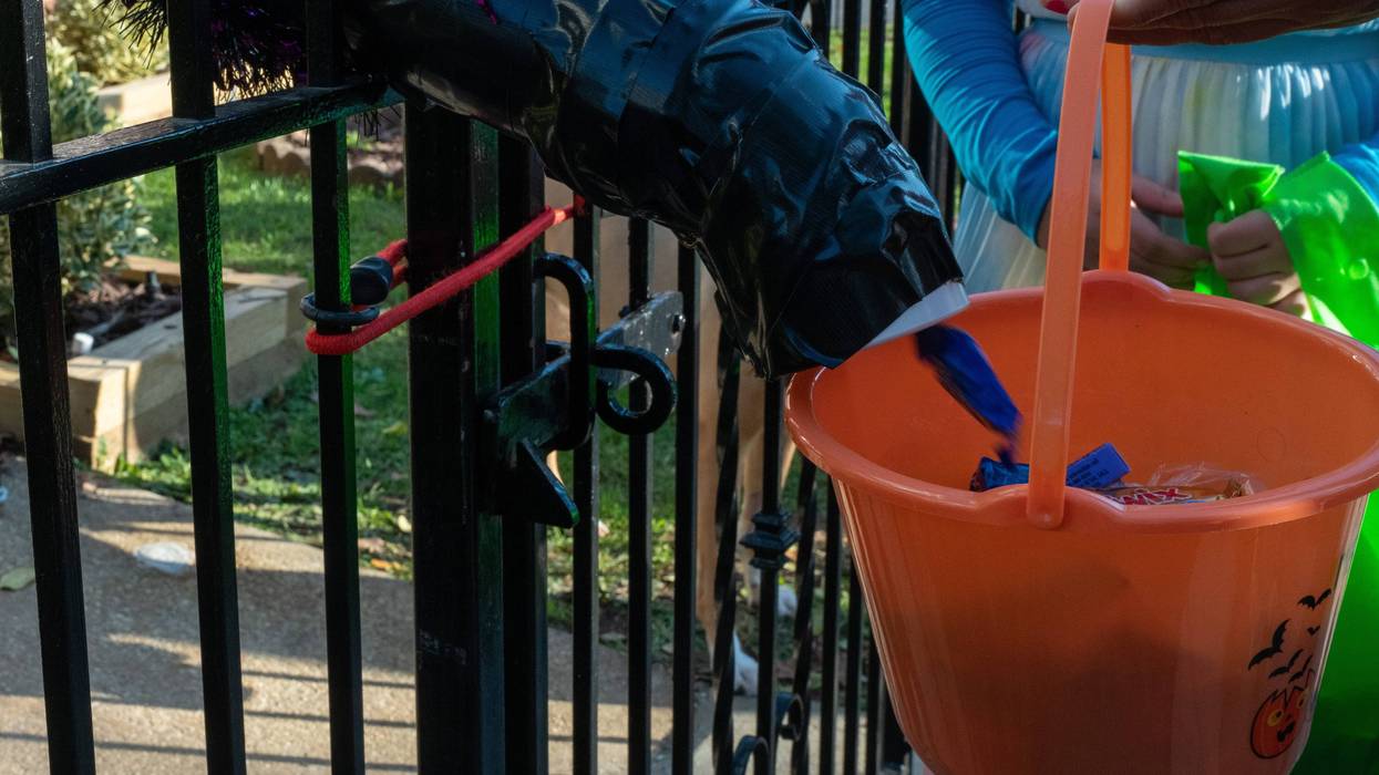 Children receive treats by candy chutes while trick-or-treating for Halloween in Woodlawn Heights on October 31, 2020 in New York City.
