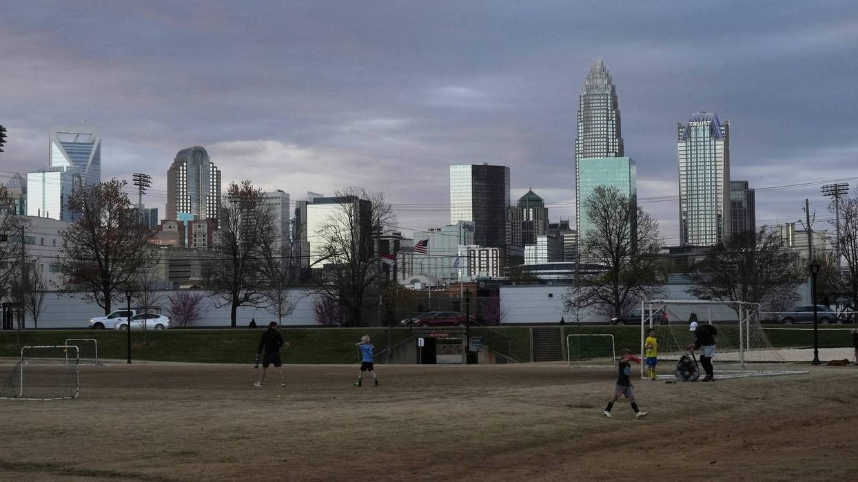 Children walk through a sports field in Independence Park under the skyline of Charlotte, N.C., on March 20, 2025.