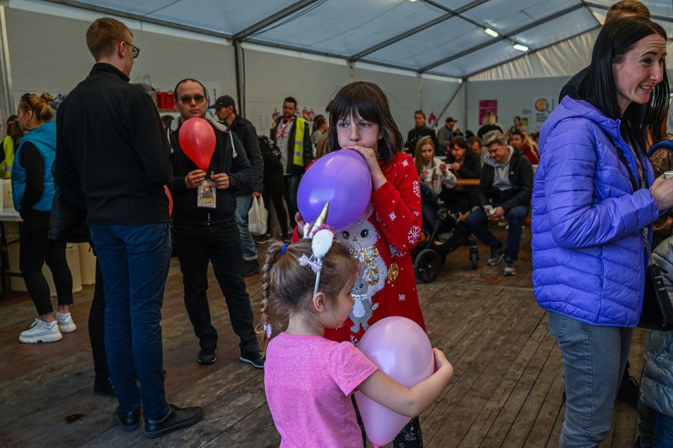 Children who fled the war in Ukraine plays with balloons inside a tent managed by the World Central Kitchen NGO next to the train station on March 29, 2022 in Krakow, Poland