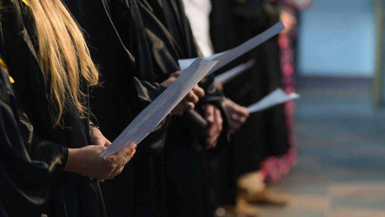 Choir singers holding musical score and singing on student graduation day in university, college diploma commencement - stock photo