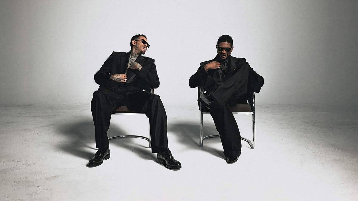 Chris Brown and Usher sitting in chairs