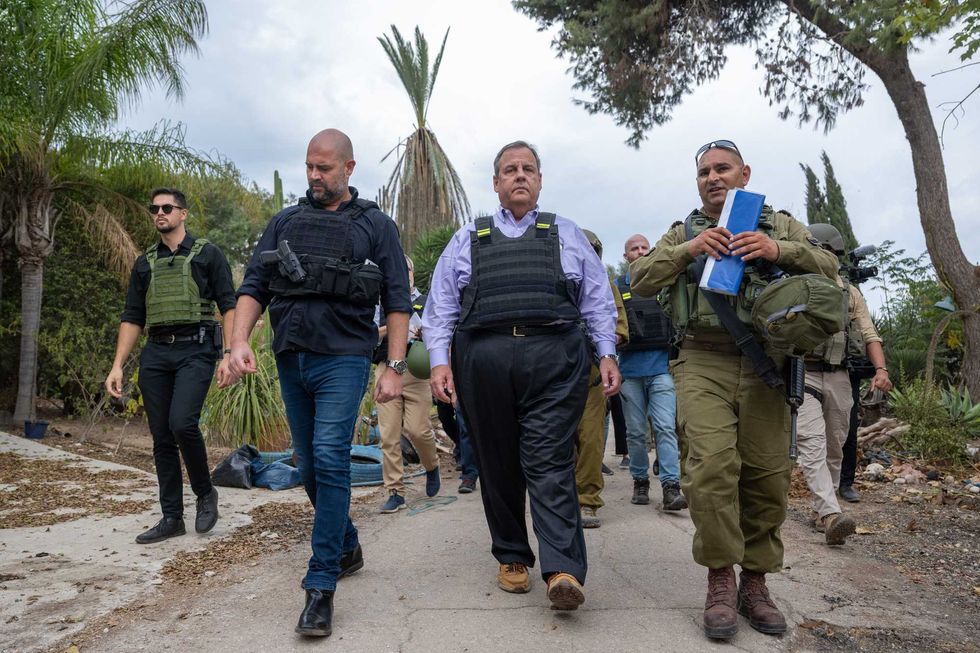 Chris Christie (C) led by IDF Spokesperson Maj. Liad Diamond (R), and Amir Ohana (L), speaker of the Knesset, visits Kibbutz Kfar Aza