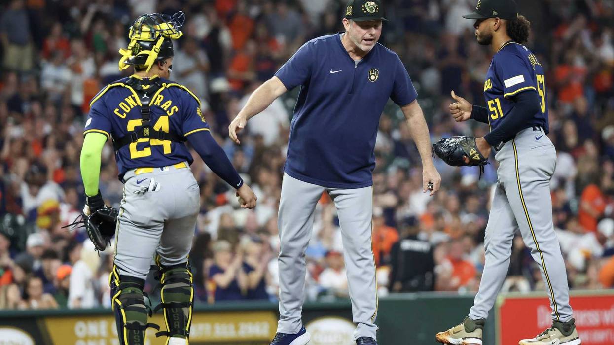 Chris Hook (84) talks with catcher William Contreras (24) and starting pitcher Freddy Peralta (51) before pitching against Houston Astros in the fifth inning at Minute Maid Park