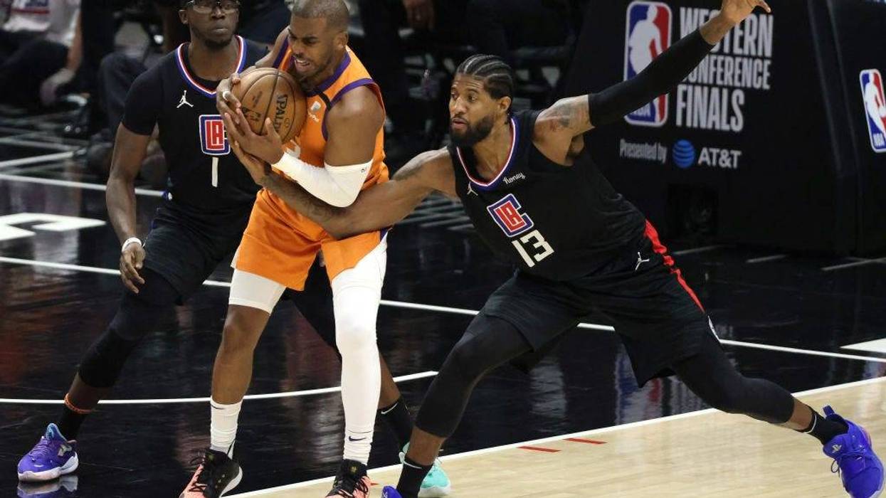 Chris Paul #3 of the Phoenix Suns protects the ball against Reggie Jackson #1 and Paul George #13 of the LA Clippers during the second half in Game Six of the Western Conference Finals at Staples Center on June 30, 2021 in Los Angeles, California. The Suns won, 130-103 to win the series. (Photo by Harry How/Getty Images)