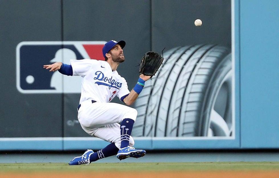 Chris Taylor #3 of the Los Angeles Dodgers catches a fly ball off the bat of Ozzie Albies #1 of the Atlanta Braves during the 8th inning of Game 3 of the National League Championship.