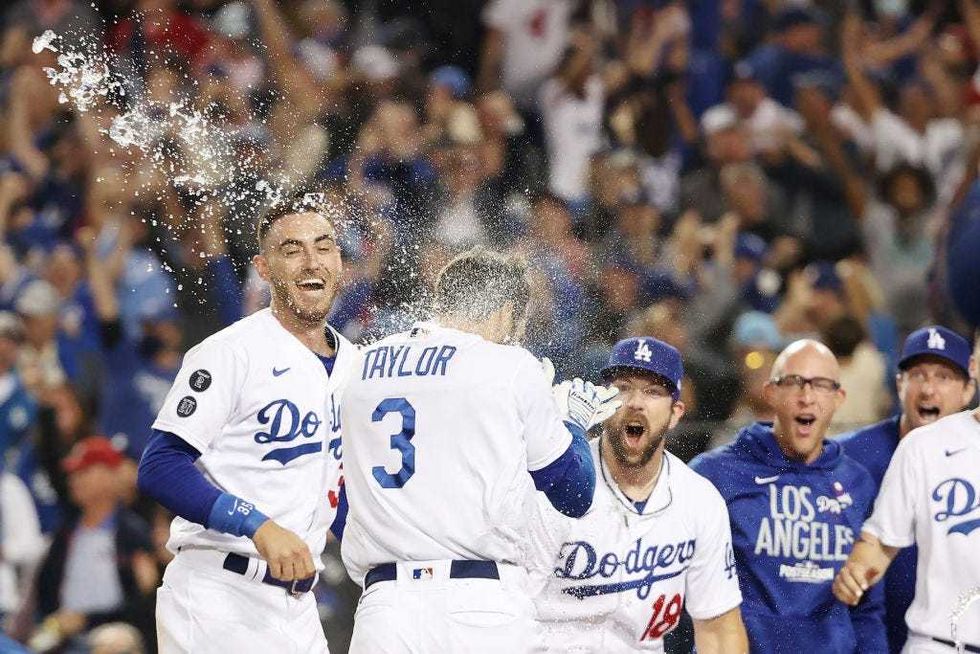 Chris Taylor #3 of the Los Angeles Dodgers celebrates with Cody Bellinger #35 and Steven Souza Jr. #18 after his walk-off two-run home run in the ninth inning to defeat the St. Louis Cardinals.