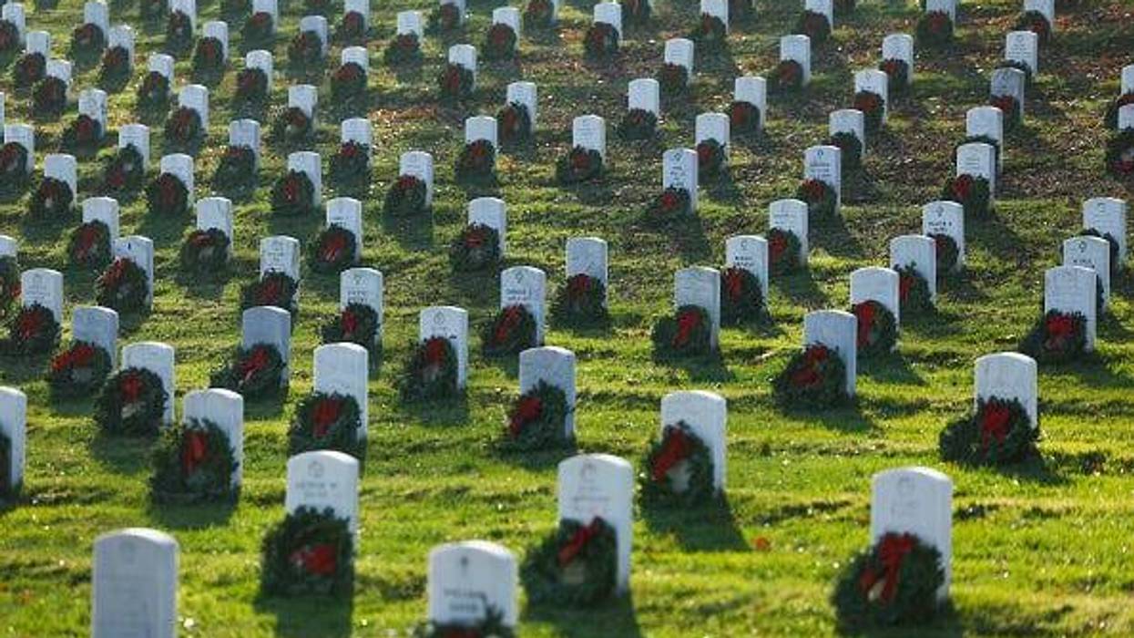 Christmas wreaths sit on a headstone during Wreaths Across America Day at the Arlington National Cemetery