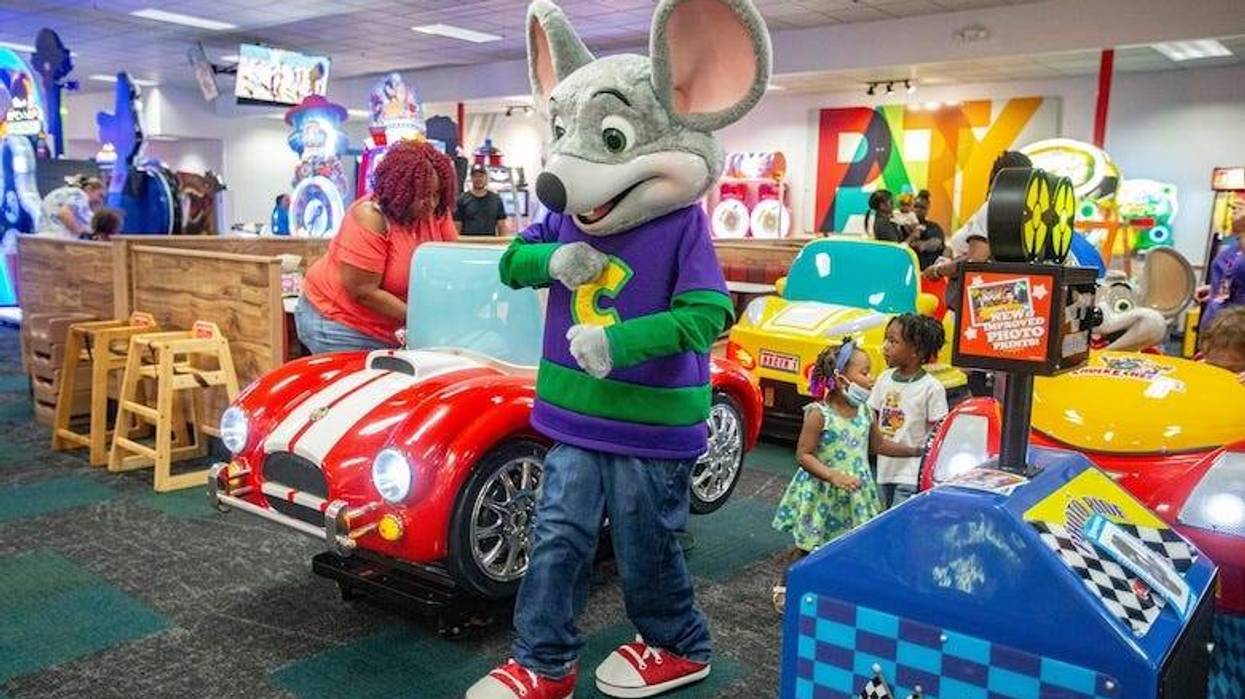 Chuck E. Cheese greets children in the arcade