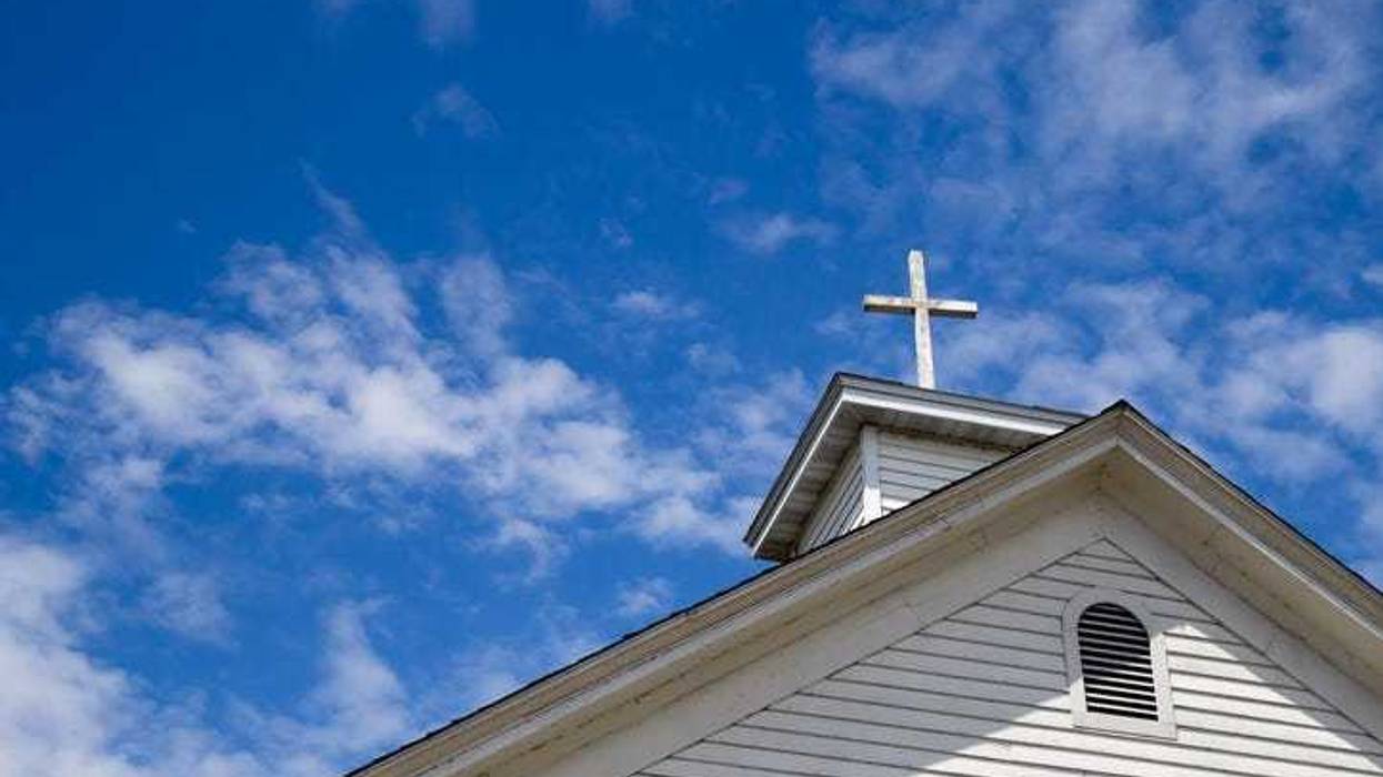 Church Steeple And Cross Set Against A Blue Sky