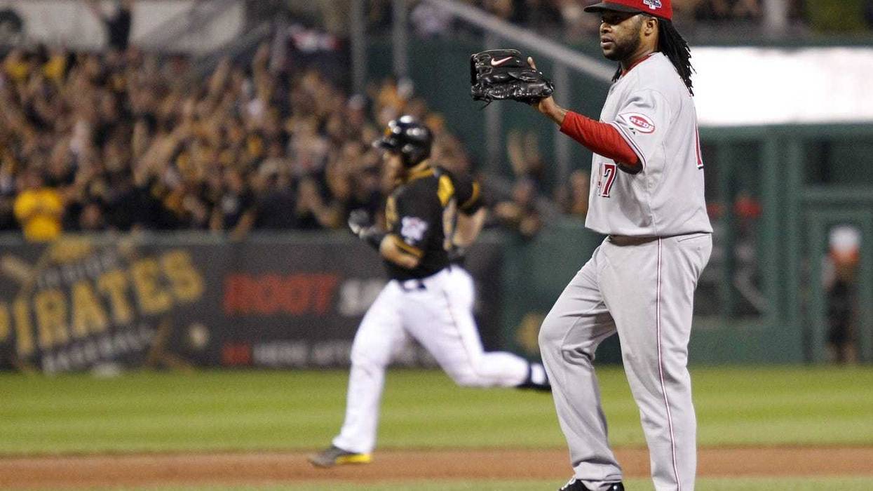 Cincinnati Reds starting pitcher Johnny Cueto (47) waits for a new ball after giving up a home run to Pittsburgh Pirates catcher Russell Martin (background left) in the second inning of the National League wild card playoff baseball game at PNC Park.