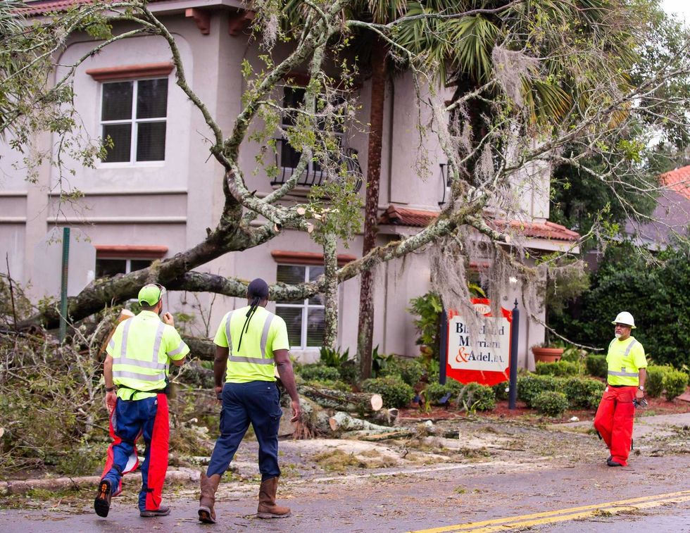 City of Ocala Public Works Street Dept. Blake Carpenter, left, Ron Hampton, center and Al Schultz, right, talk about clearing a fallen tree at Blanchard, Merriam and Adel law firm at 1007 SE Ft. King Street in Ocala, Fla.