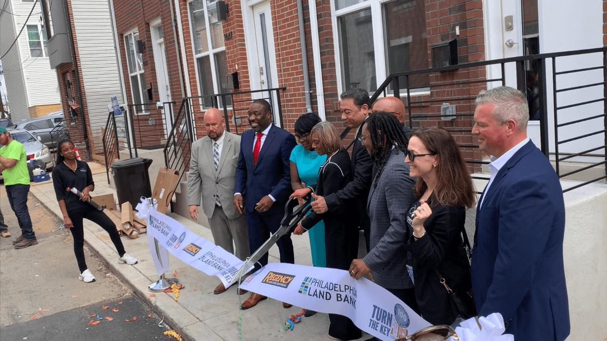City Officials cut the ribbon in front of Kenya Hinton's new house in Brewerytown, the 100th in the city's Turn the Key program.