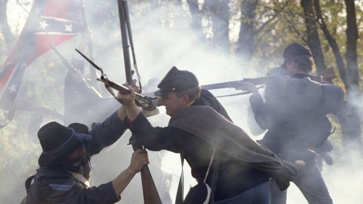 Civil War reenactors fighting with rifles and bayonets.