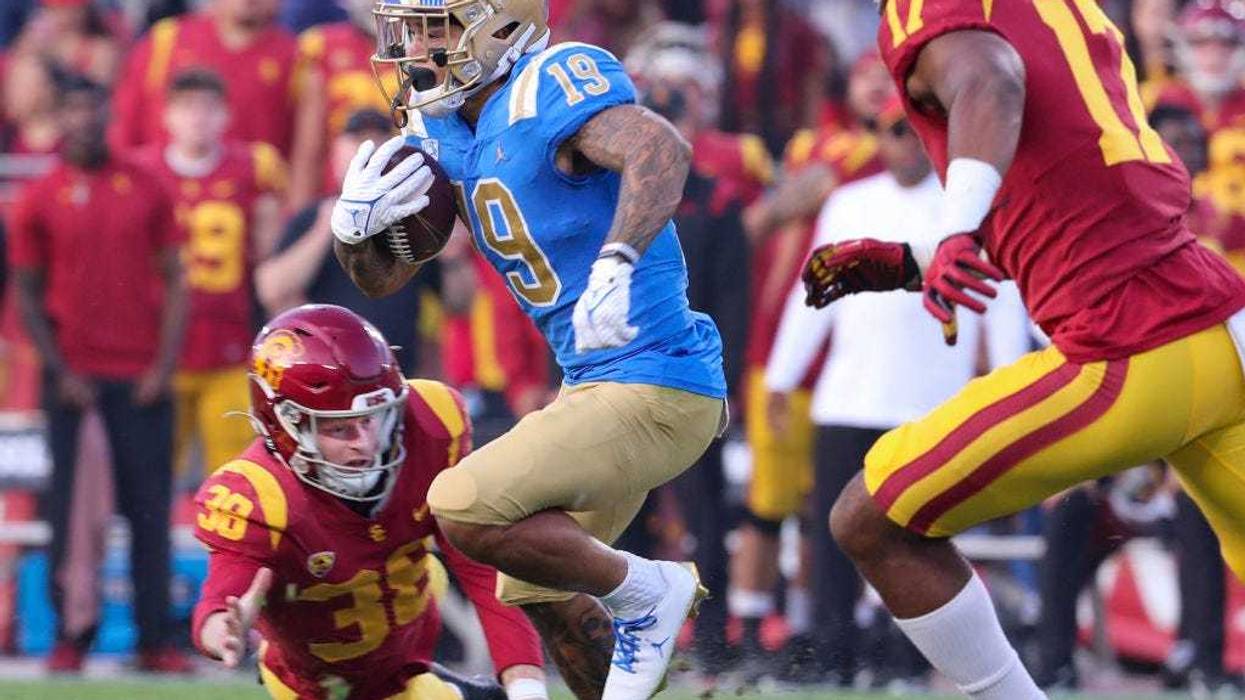 CLA running back Kazmeir Allen outruns USC kicker Alex Stadthaus, left, and linebacker Micah Croom, right, as he runs a 100-yard kickoff return for a touchdown.