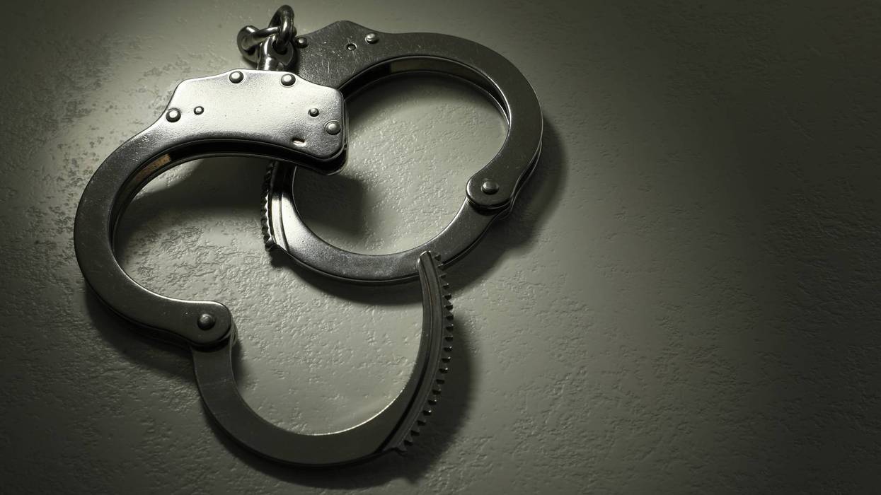 Classic chain handcuffs on grey table, closeup. Space for text