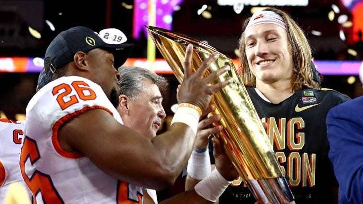 Clemson quarterback Trevor Lawrence, right, celebrates with the national championship trophy after beating Alabama during the College Football Playoff championship game on Jan. 7, 2019, at Levi's Stadium in Santa Clara, California.