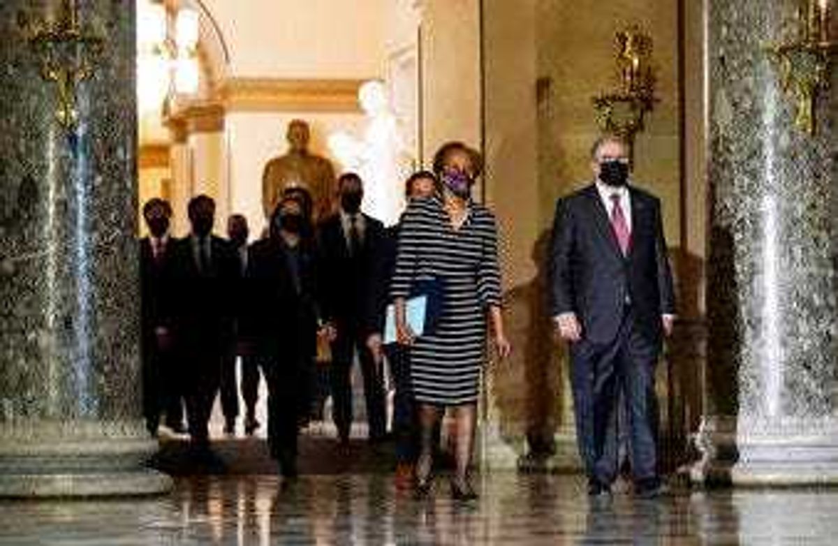 Clerk of the House Cheryl Johnson along with acting House Sergeant-at-Arms Tim Blodgett, lead the Democratic House impeachment managers as they walk through Statuary Hall in the Capitol. (AP Photo/Susan Walsh)