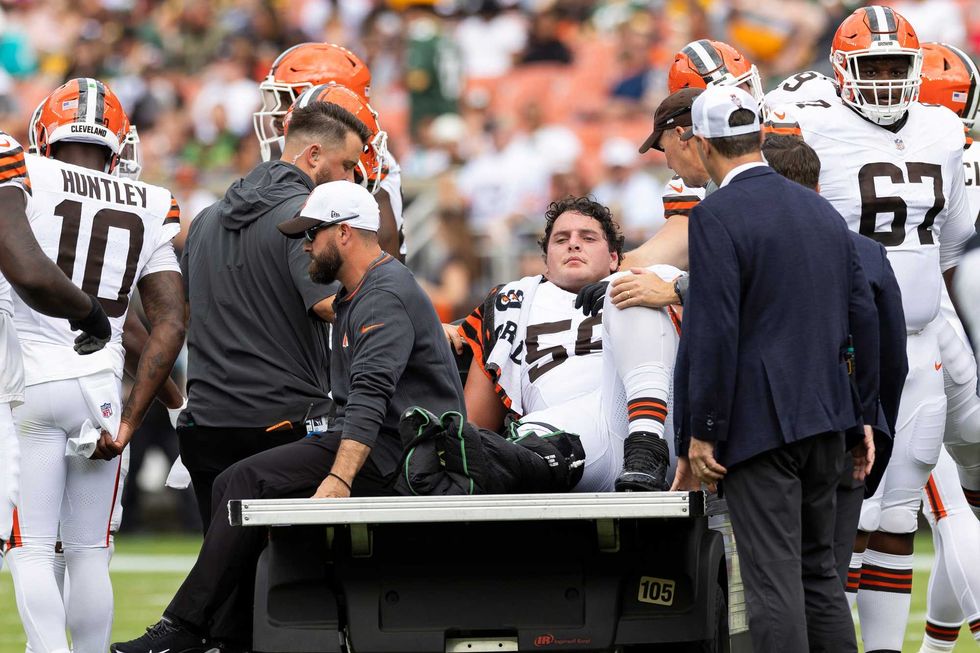 Cleveland Browns center Luke Wypler (56) rides the medical cart back to the locker room following an injury during the second quarter against the Green Bay Packers at Cleveland Browns Stadium.