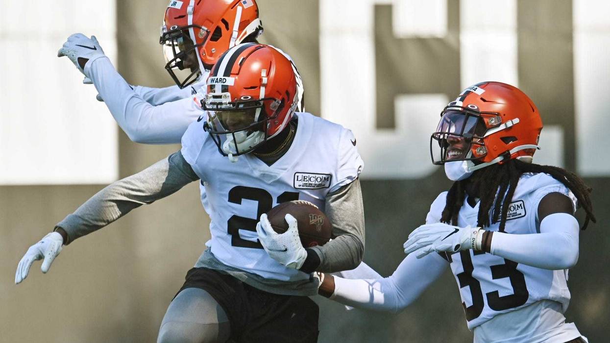 Cleveland Browns cornerback Denzel Ward (21) celebrates with cornerback Donnie Lewis Jr. (37) and cornerback Donovan Olumba (33) after an interception during training camp at the Cleveland Browns training facility.