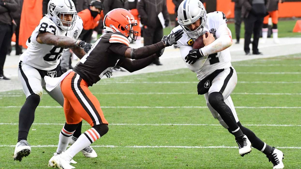 Cleveland Browns cornerback Denzel Ward (21) tackles Las Vegas Raiders quarterback Derek Carr (4) during the second half at FirstEnergy Stadium.