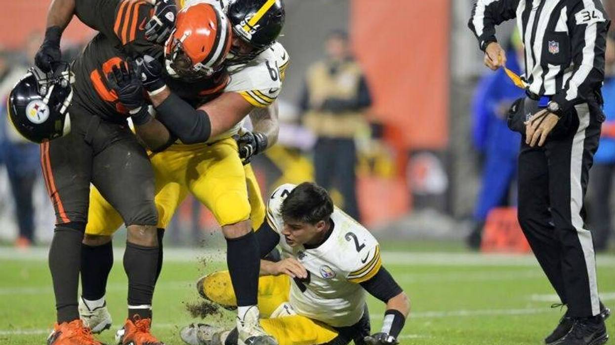 Cleveland Browns defensive end Myles Garrett (95) takes Pittsburgh Steelers quarterback Mason Rudolph's (2) helmet off.