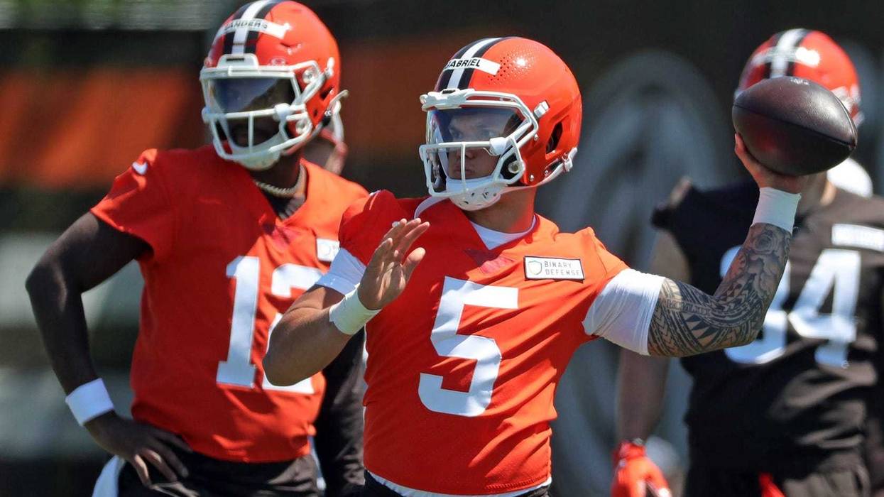 Cleveland Browns quarterback Dillon Gabriel (5) throws as quarterback Shedeur Sanders (12) looks on during rookie minicamp May 9, 2025, in Berea.